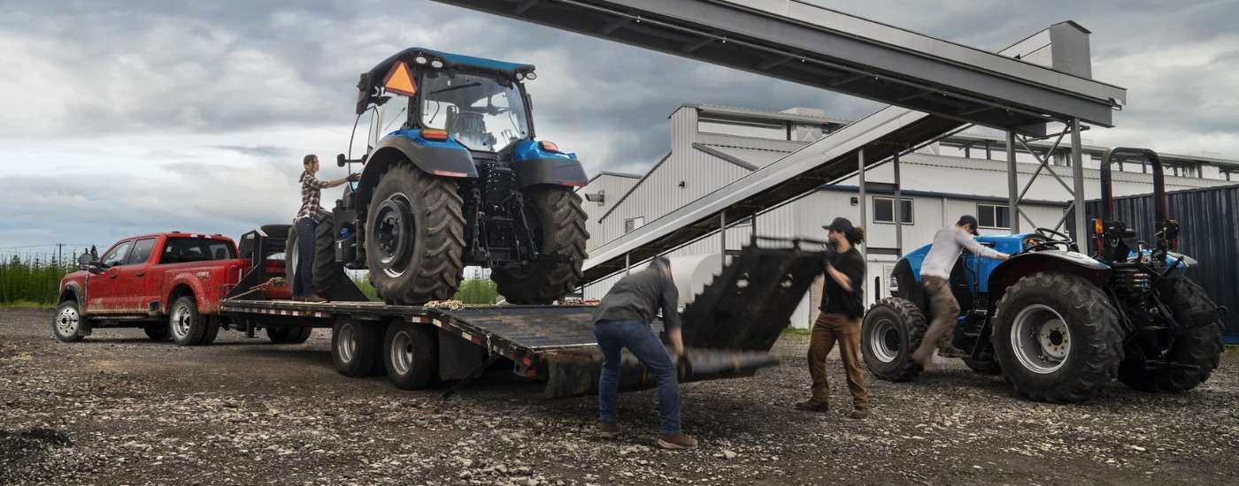 Red 2023 Ford F-450 XL towing a tractor